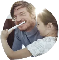 Daughter brushing her father&amp;#39;s teeth while playing.