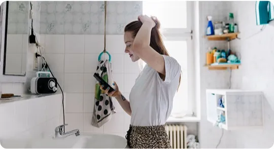 Woman checking her phone in the bathroom.