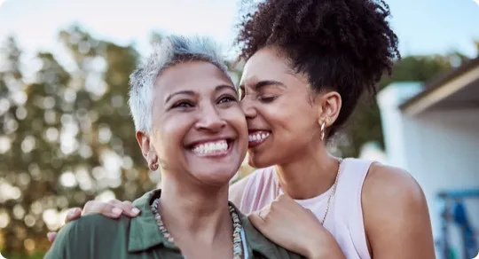 Daughter kissing her mother on the cheek.