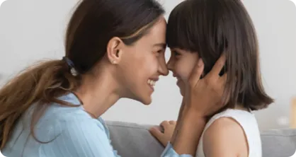 Mother and daughter touching each other by noses.